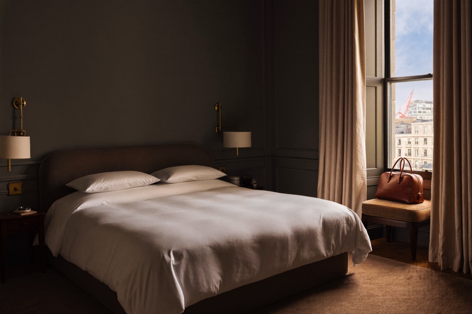 A boutique serviced-apartment bedroom with hotel-style bedding.